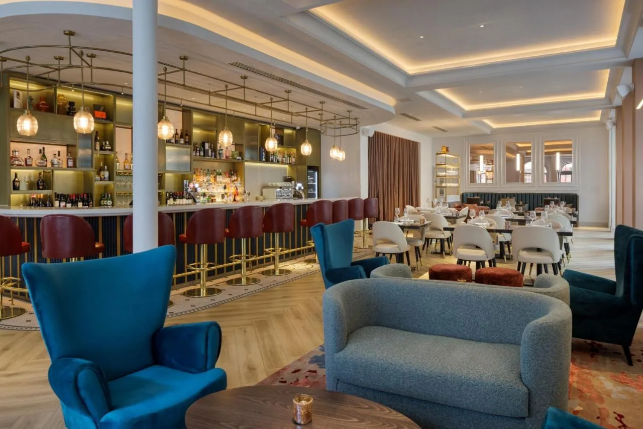 a restaurant with blue chairs and a bar at The Memoir Club in London