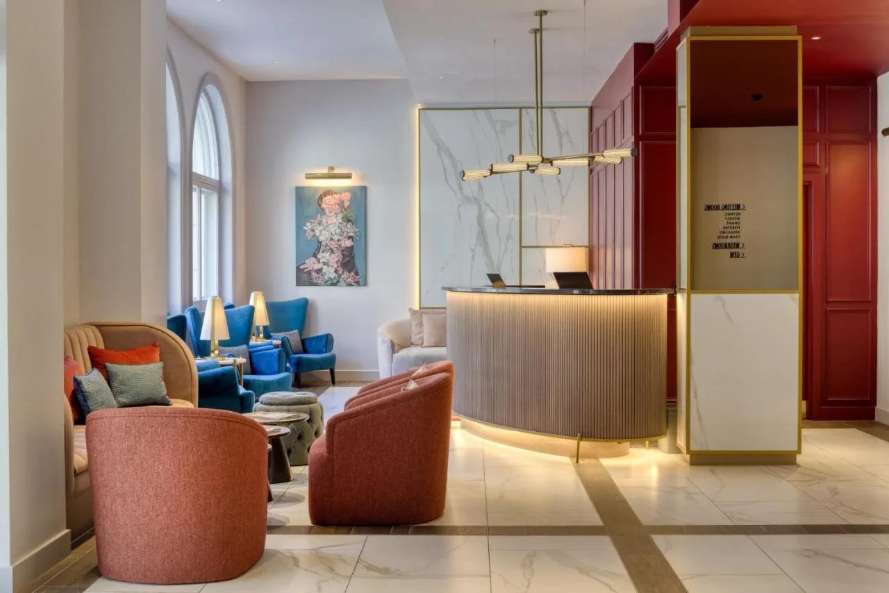 a lobby with chairs and a bar in a building at The Memoir Club in London