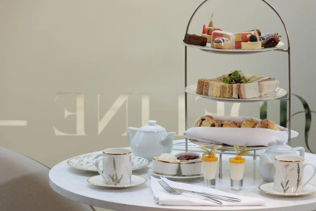 a table with a tray of pastries and coffee cups at The Memoir Club in London